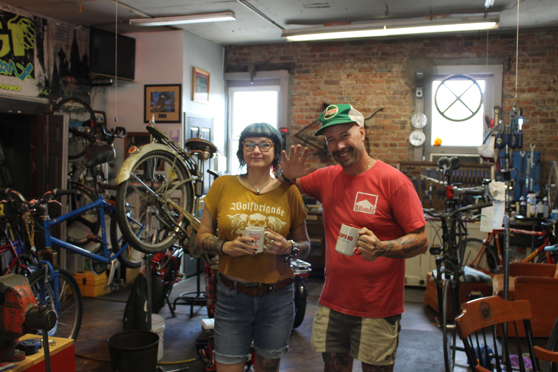 Andrew and Dee Hund inside the shop, smiling and holding Radford coffee mugs